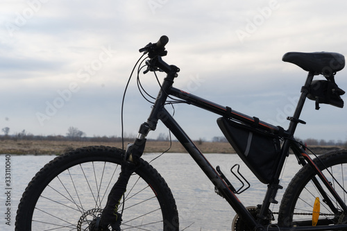 iew of the lake and sky with sunset from behind a black sports mountain bike