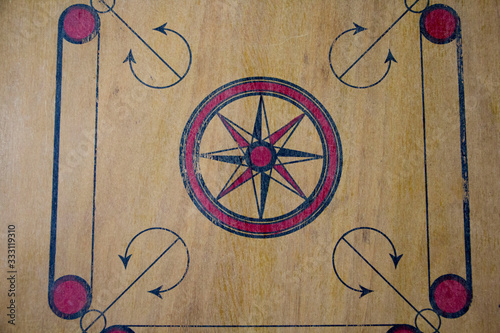 A game of carom set and ready to play. A game of carrom with pieces carrom man on the board carrom. Carom board game, selective focus.