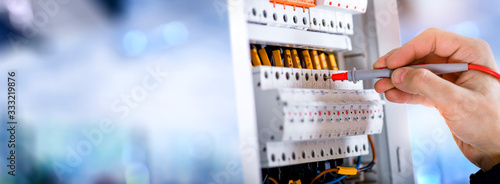 Electrician engineer installing and test electric connection wires of fuse switch box.