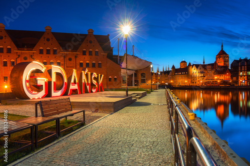 City of Gdansk outdoor sign over Motlawa river at dusk, Poland.