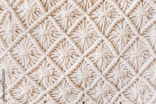 Close-up of hand made macrame texture pattern. ECO friendly modern knitting DIY natural decoration concept. Flat lay.