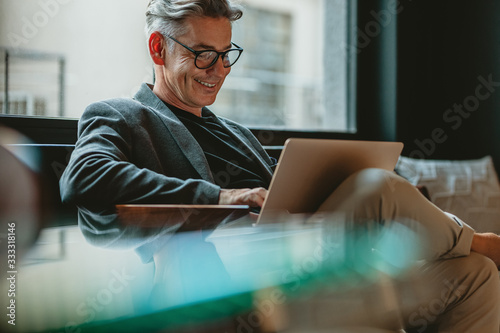 Business professional working on laptop in office lobby