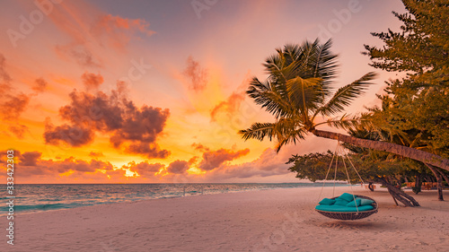 Tropical beach sunset as summer landscape with luxury resort beach swing or hammock and white sand and calm sea for sunset beach landscape. Tranquil beach scenery vacation and summer holiday concept.