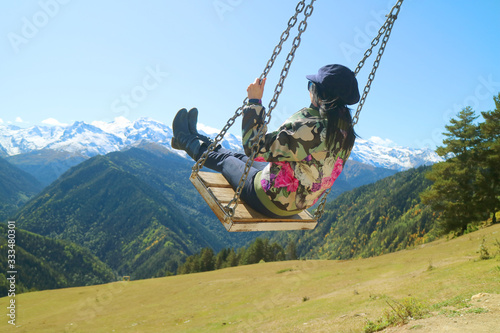 Female Trekker on the Mountain Swing with Stunning View of Caucasus Mountain in Mestia, Svaneti Region of Georgia