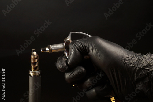 Cleaning the spark plug with compressed air. Internal combustion engine service.