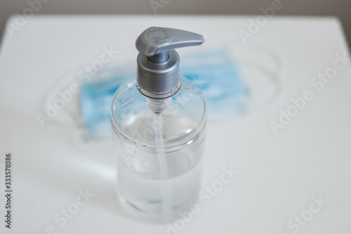 Kit para combater o coronavirus: álcool em gel e máscara na mesa de cabeceira.