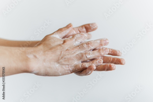 Detalhe de mãos femininas com espuma de sabonete. Lavar as mãos para combater o coronavírus.