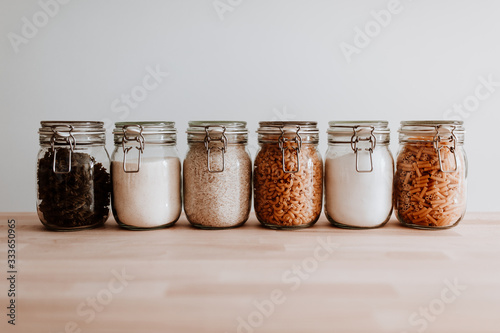 Six glass jars full with dried uncooked food ingredients