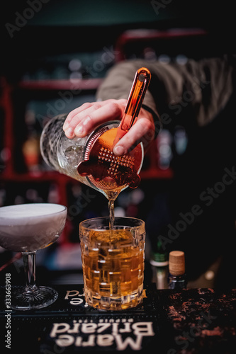  bartender pours a cocktail