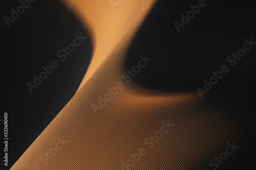 Abstract desert sand dunes with deep shadows and early morning light. Mhamid, Morocco.