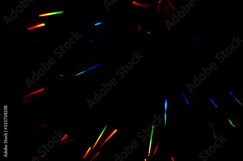 Abstract dark background of rainbow iridescent light streaks. Prismatic color light streaks