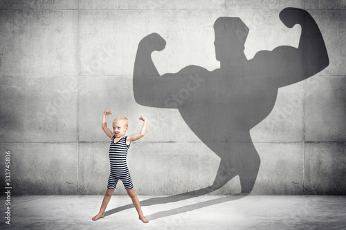 Boy in vintage costume of athlete .The kid dreams of becoming a big and strong athlete.