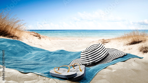 blue towel with hat and summer beach 