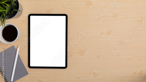 Wooden Table Office desk top view design workspace layout left have plant, coffee cup, pen on top notebook, show mock up tablet isolated and empty right area for insert text or other