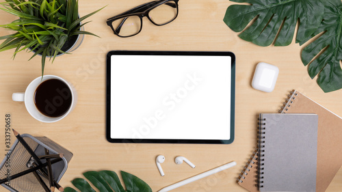 Wooden Table Office desk top view design workspace layout center show mock up tablet isolated for insert on screen around space have leaf, notebook, pen, earphones, coffee cup, plant, glasses