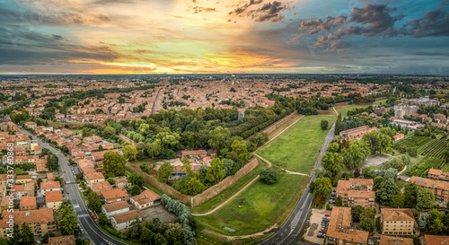 Aerial sunset panorama of the bastions and medieval wall of the center of Ferrara Italy with stunning yellow, blue sky colors