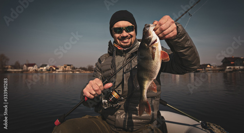 Fishing background. Happy angler with perch fishing trophy.