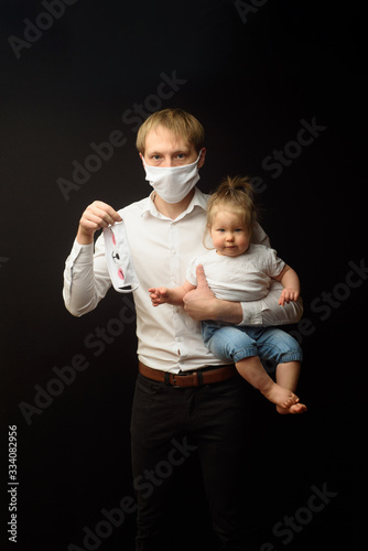 father in a medical mask holds his little daughter. The concept of protecting children during the epidemic of coronavirus