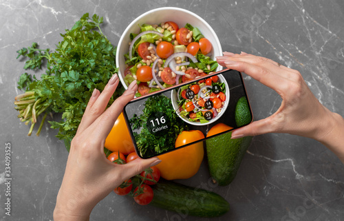 Female using dieting app on a smartphone to track nutrition facts and calories in her food