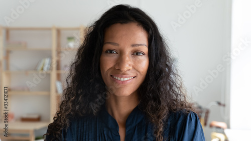 Headshot portrait of smiling african American female employee look at camera posing in modern office, happy biracial young businesswoman show confidence and motivation, work leadership concept