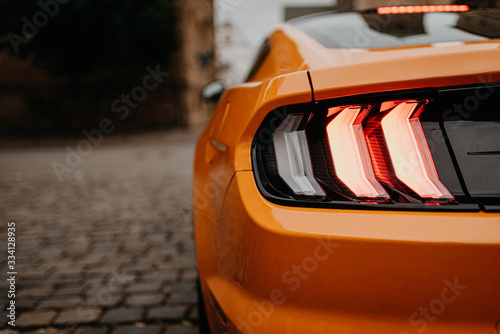 rear lights of orange car on the street from behind with copy space