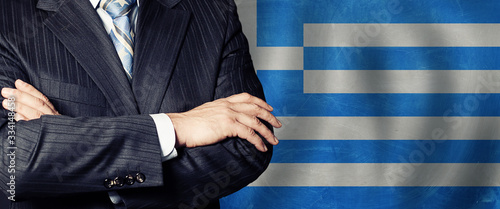 Politician crossed arms of on Greek flag background