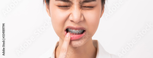 Face of asian woman finger touches a toothache maybe because of poor care.