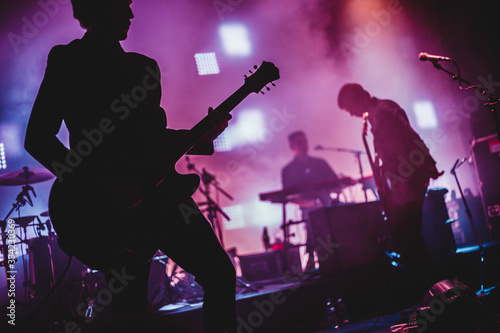 Blurred background light on rock concert with silhouette of musicians