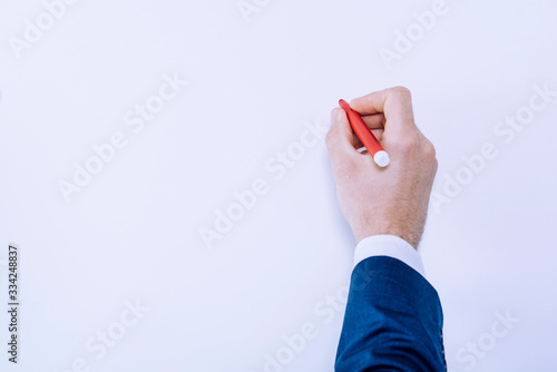 mano masculina escribiendo con un rotulador rojo en un fondo liso