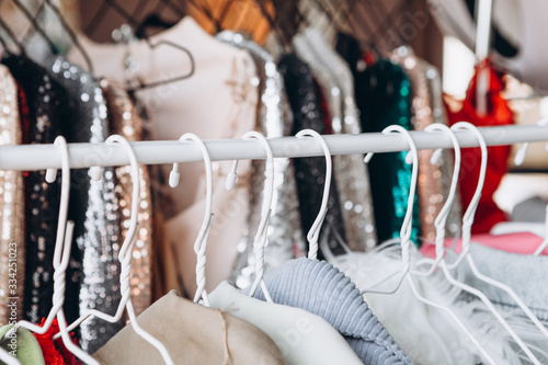 a lot of clothes hangers that are closely located next to each other in a store with women's clothing, an atmosphere of women's space with a large selection of colorful clothes, noise effect