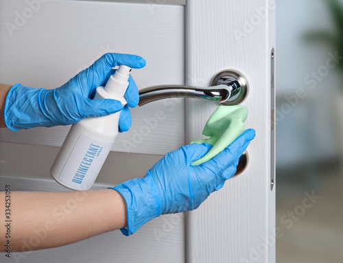 Sterile cleaning of door handles during a coronavirus pandemic. Alcohol-based cleaner, gloves and a napkin.