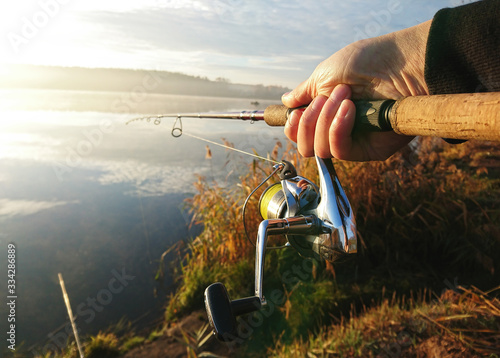 Amateur angler is fishing on autumn in the lake