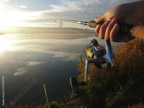 Amateur angler is fishing on autumn in the lake