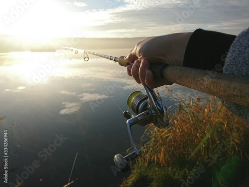 Amateur angler is fishing on autumn in the lake