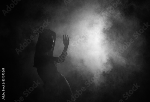 Female silhouette in shadow and smoke