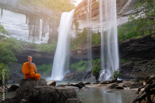 Buddha monk practice meditation with waterfall