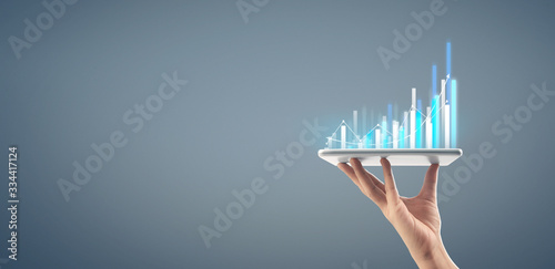  Graph growth and increase of chart positive indicators in his business,tablet in hand