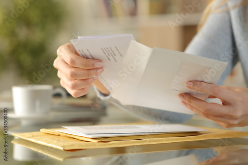 Girl hands opening an envelope on a desk at home