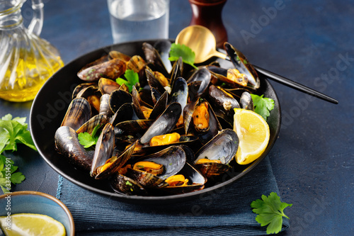 Close up of a plate with freshly coocked mussels on dining table