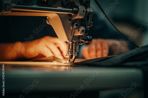 Sewing machine and men's hands of a tailor