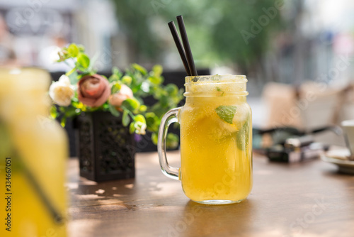 Glass of yellow alcohol-free cocktail with lemons and mint