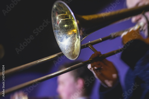 Concert view of a trombone player trombonist with musical jazz band performing in the background