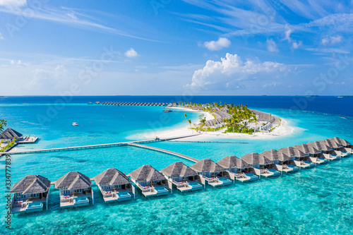 Perfect aerial landscape, luxury tropical resort or hotel with water villas and beautiful beach scenery. Amazing bird eyes view in Maldives, landscape seascape aerial view over a Maldives