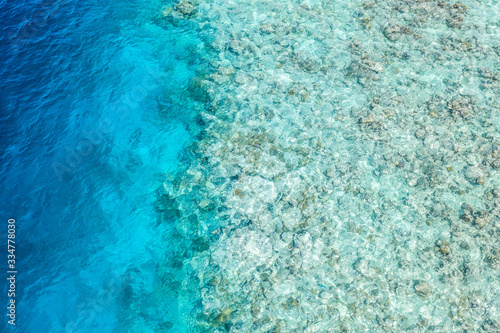 Sea aerial view, top view, amazing nature background. The color of the water and bright azure beach, shallow water and coral reef. Seascape from above