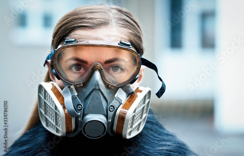 Young woman wearing full face respirator protective mask and goggles, extreme coronavirus protection concept