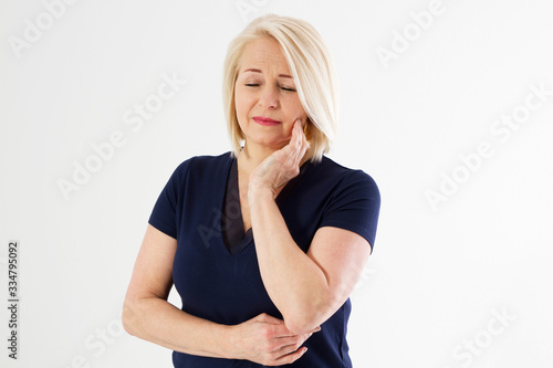 woman with toothache, Attractive middle aged woman pressing her bruised cheek with a painful expression as if she's having a terrible tooth ache. Female tooth pain cocncept, medicine dentistry concept