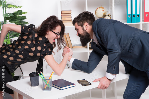 Prove how strong you are. Business partners get into armwrestling competition. Colleagues in competitive relations. Business relations. Professional couple relations. Relations between man and woman