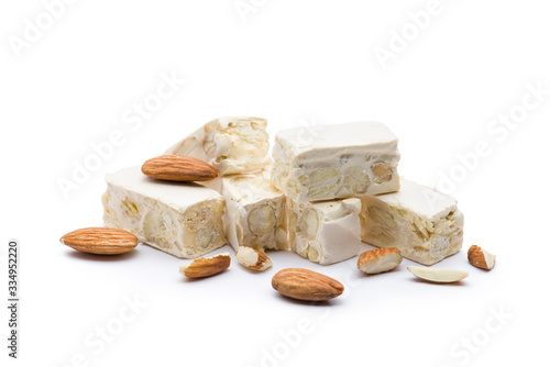 small nougat pieces with almonds, on white background.