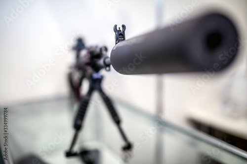 Sound suppressor or sound moderator and Iron sights on the gun barrel of semi-automatic rifled carbine, standing on stand. Iron sight in shallow DoF(depth of field).