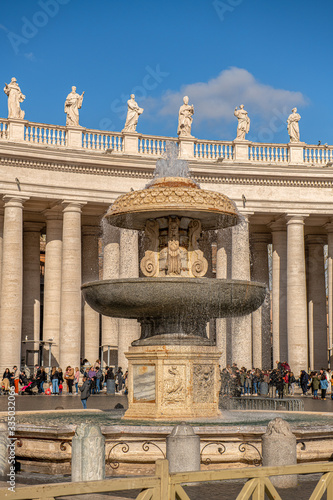 Piękna fontanna na placu świętego Piotra w Watykanie. W tle widoczna kolumnada oraz zabytkowe rzeźby. Włochy, Europa